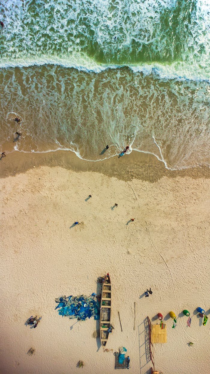 The Art of Drawing Readers In: Your attractive post title goes here Drone shot capturing the vibrant beach scene in Accra, Ghana with people and boats.